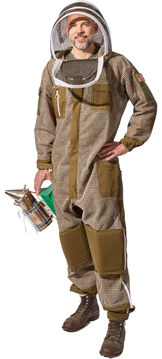 A man wearing a full beekeeping suit with a mesh face veil, holding a metal bee smoker against a plain white background.
